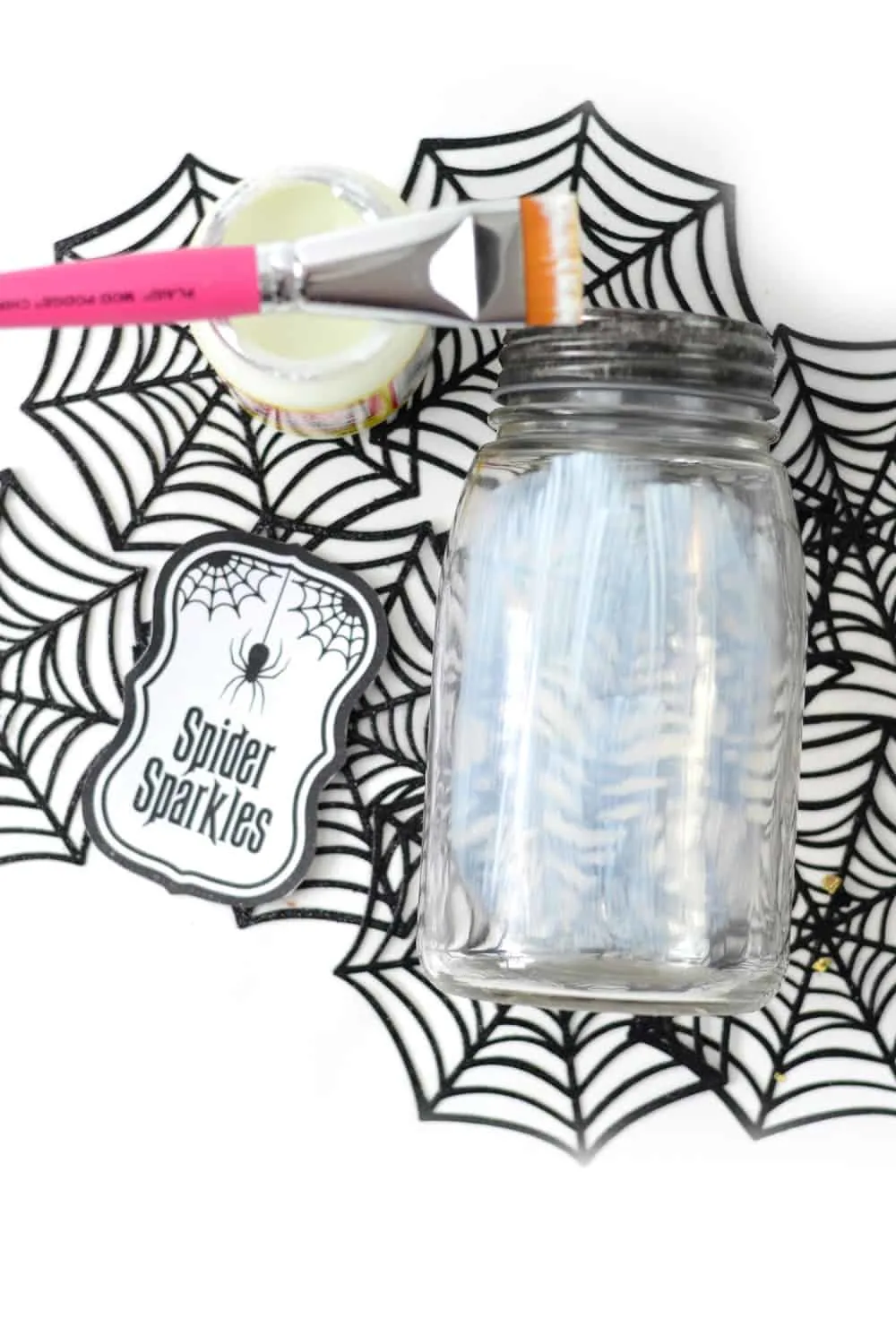 Painting a layer of glow in the dark Mod Podge onto a clear jar
