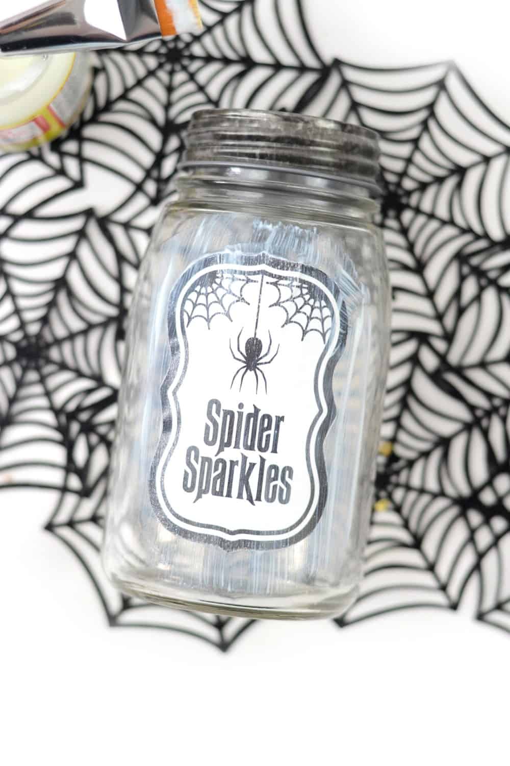 Applying a label to a jar for Halloween party favors with Mod Podge