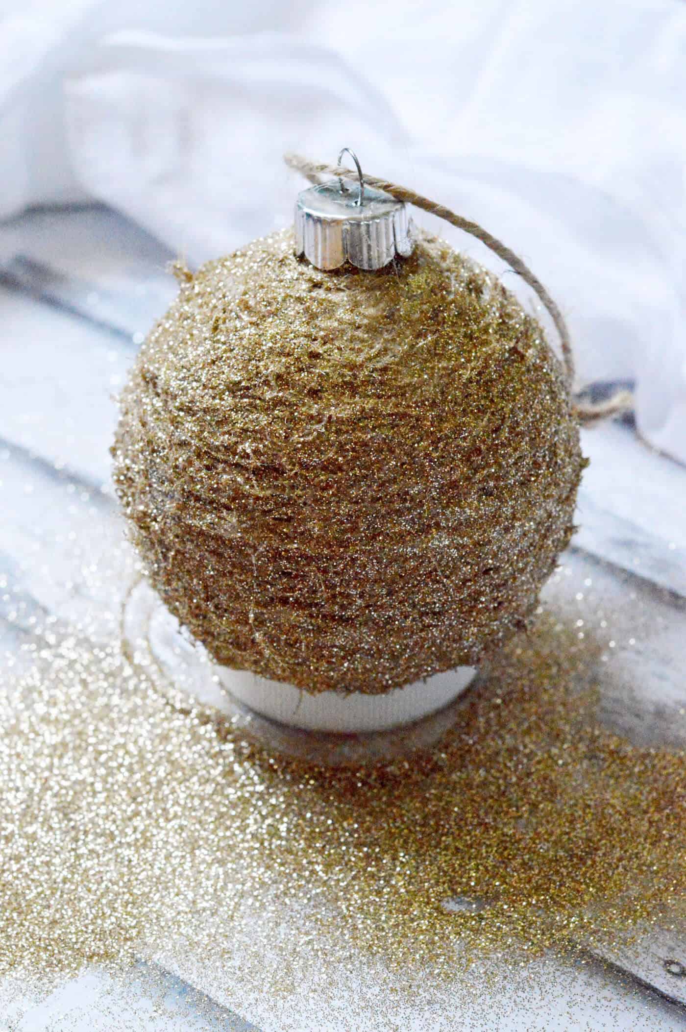 Make your own rustic glitter ornament using twine and Mod Podge! This is so easy - you'll want a whole tree of these. So pretty!