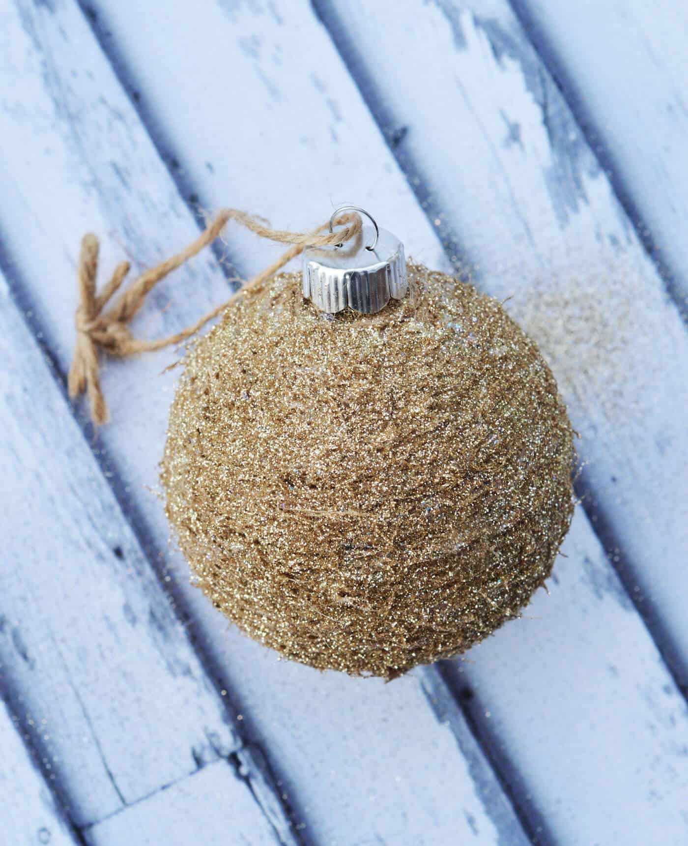 Make your own rustic glitter ornament using twine and Mod Podge! This is so easy - you'll want a whole tree of these. So pretty!