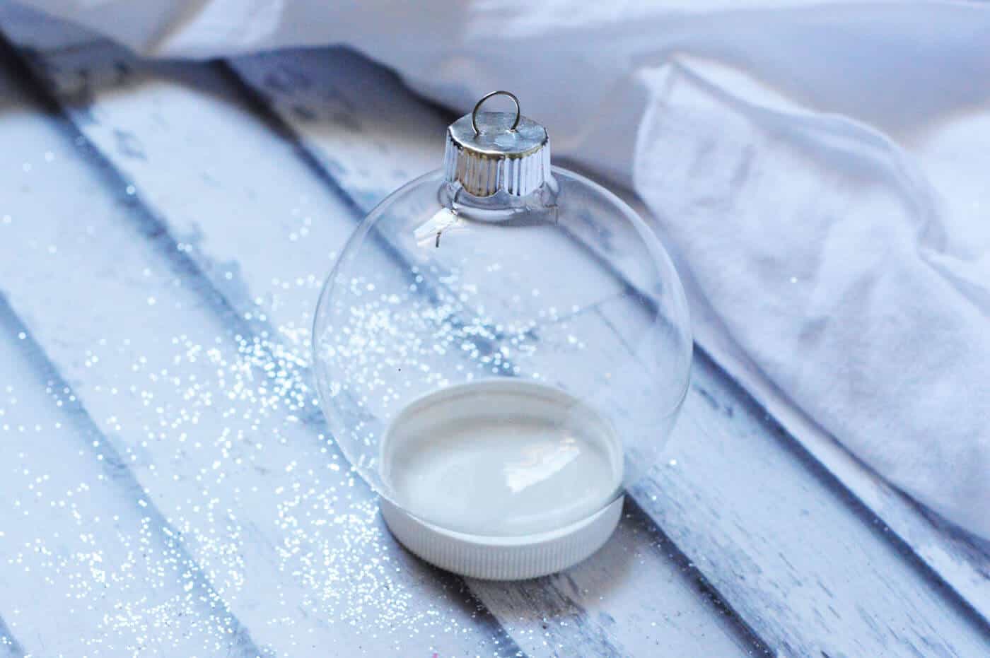 Clear glass ornament sitting in a plastic lid