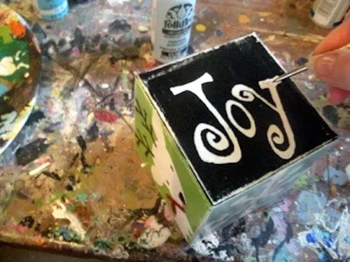 Painting the word JOY in white on the black background