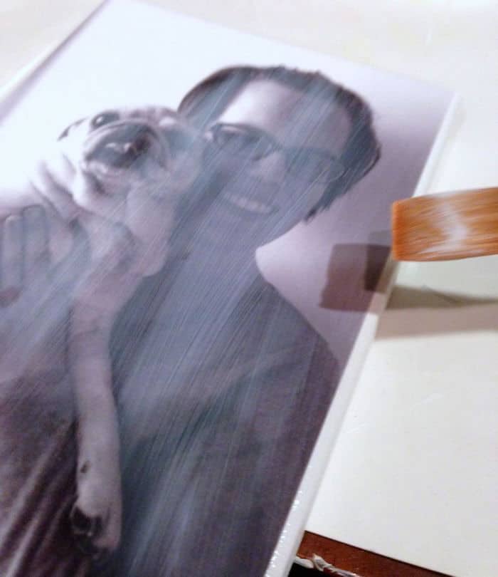 Applying Mod Podge over the top of a photo with a paintbrush