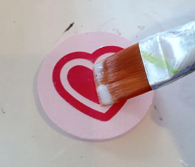 Mod Podging paper to the top of a wood circle