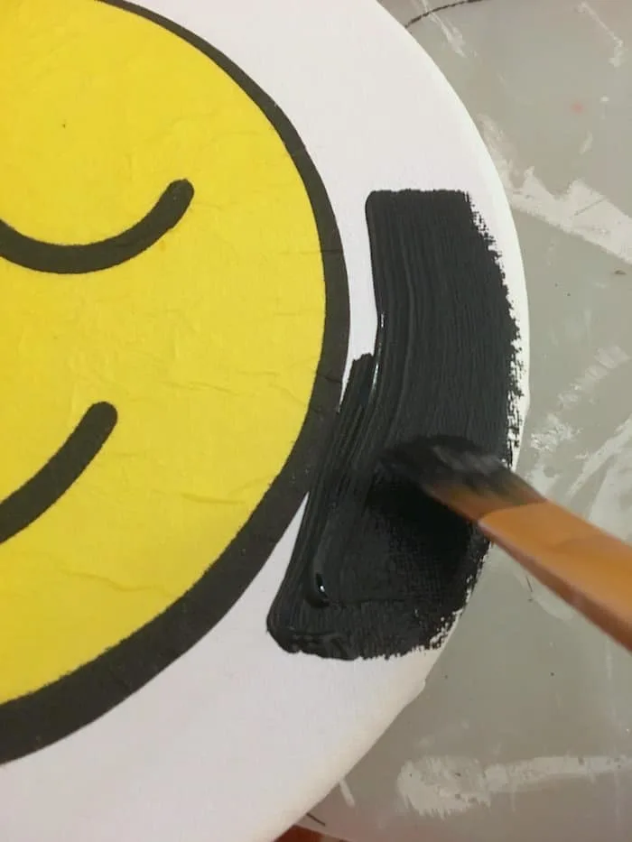 Painting the edges of the canvas with black acrylic paint
