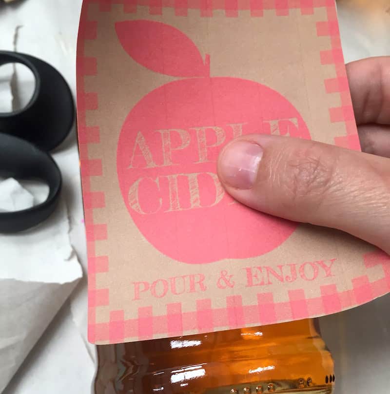 Applying an Avery 8164 sticker label to a clear glass bottle