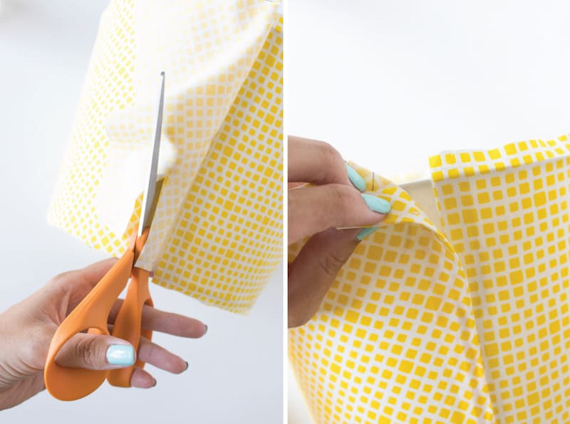 Trimming fabric with orange handled scissors on a Mod Podge lamp shade