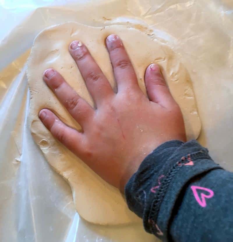 child's hand in air dry clay