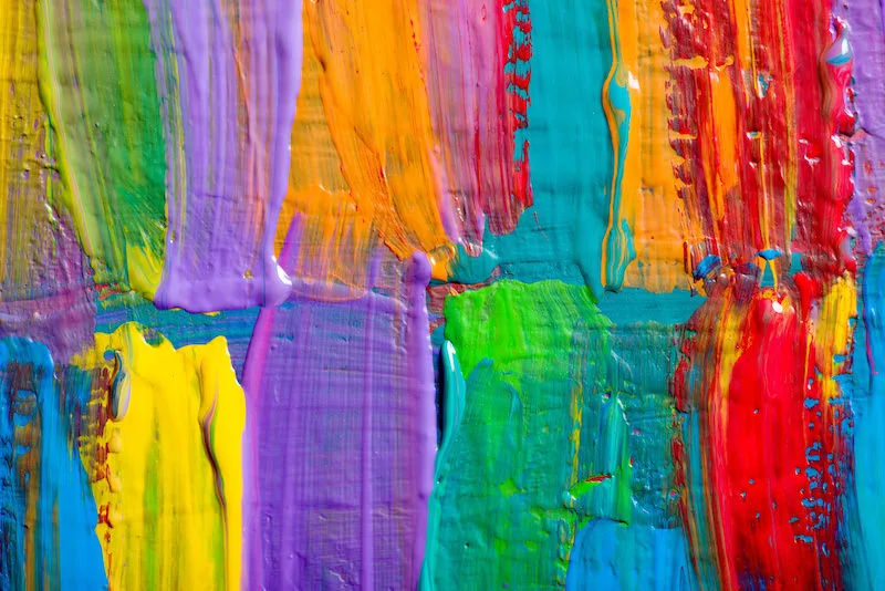 various colors of paint on a surface, still wet