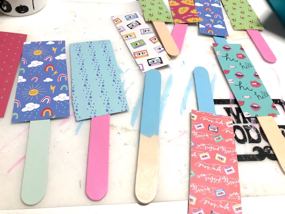 Scrapbook paper drying on popsicle sticks