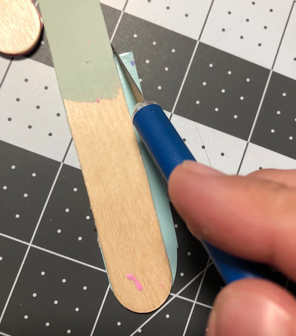 Trim popsicle stick with a craft knife