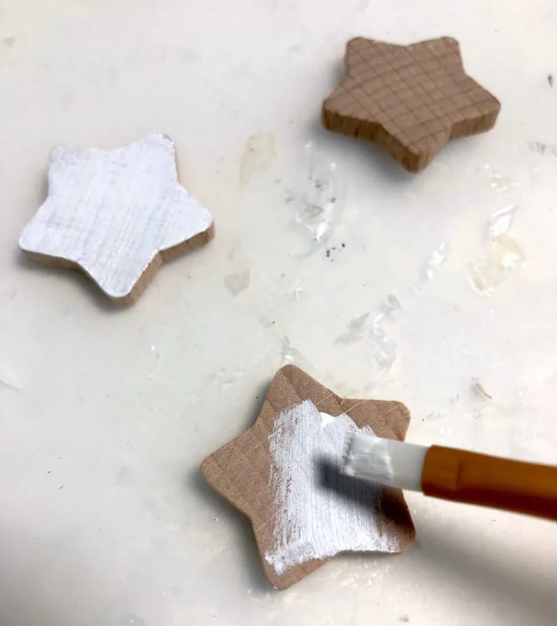 Painting wooden stars with white acrylic paint