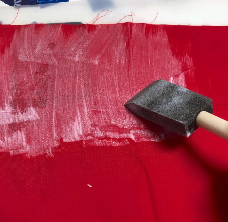 Applying Mod Podge to fabric with a sponge brush