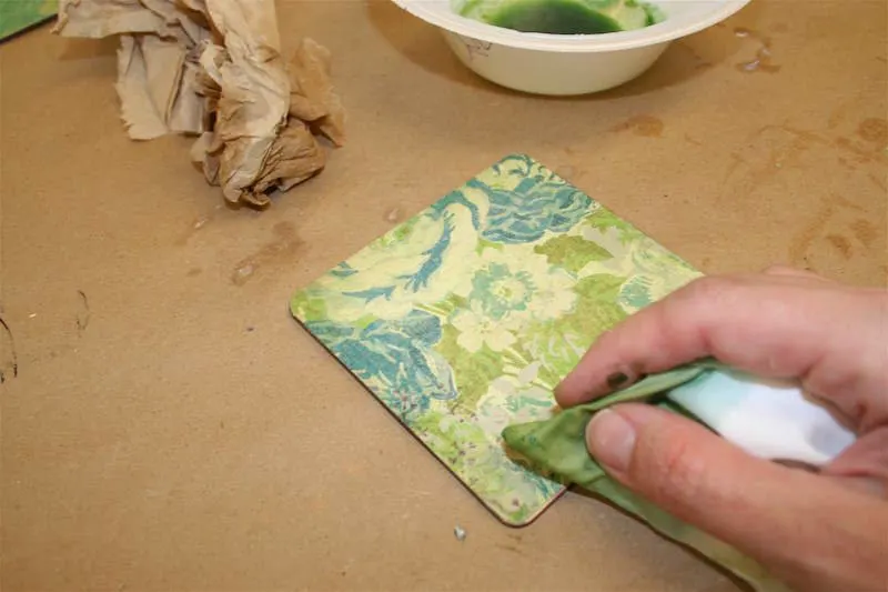 Add alcohol ink to the edges of a coaster with a paper towel