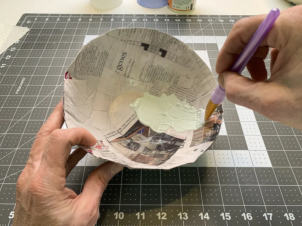 Painting a newspaper bowl with acrylic paint