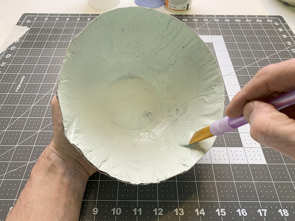 Pintando o interior de uma tigela de papel machê Mod Podge com tinta acrílica