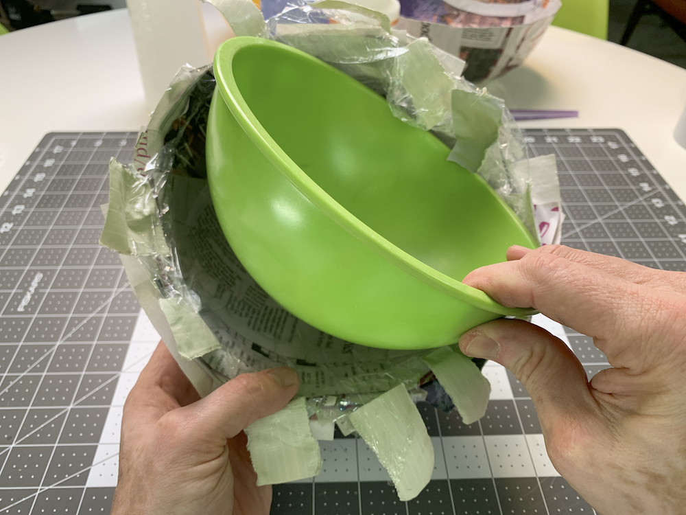 Removendo uma tigela verde de um molde de papel machê