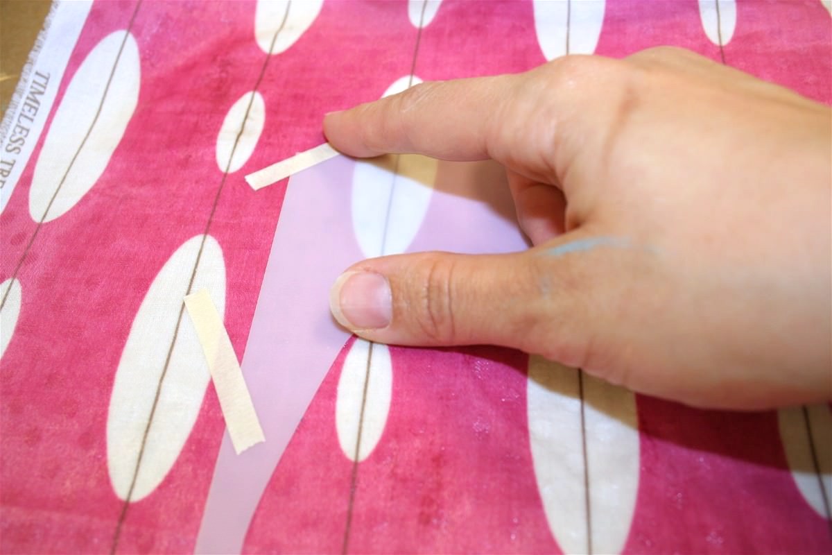 Taping a stencil down to fabric