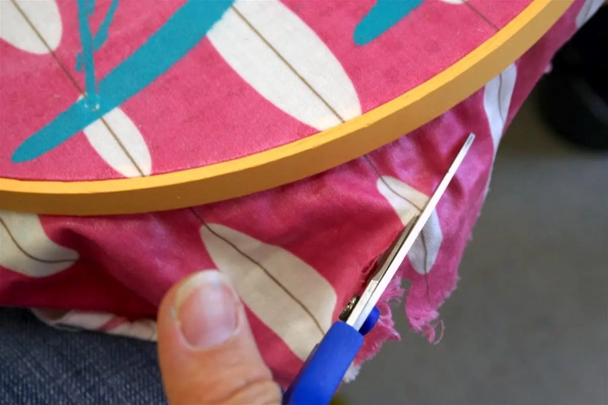 Trimming the edge of the fabric with a pair of scissors