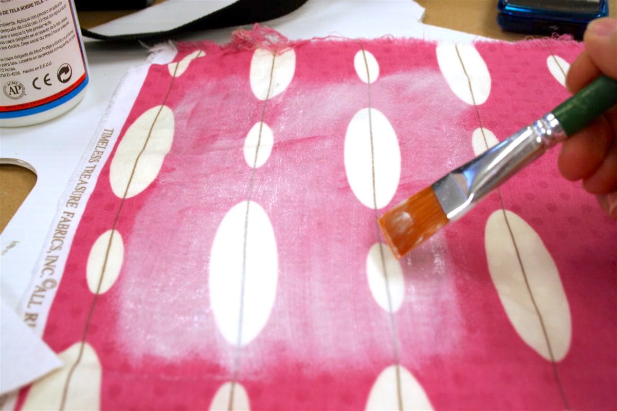 Using Mod Podge to prepare the fabric by applying a layer on top