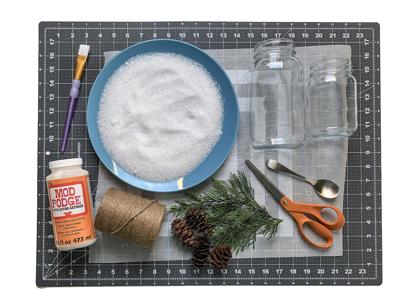 Mod Podge with epsom salt fir branches scissors twine and a paintbrush