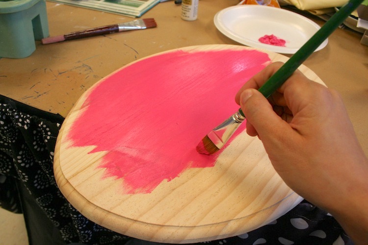 Painting a plaque with pink acrylic craft paint