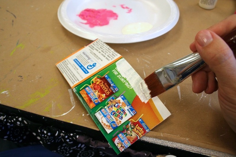 Painting the ends of cereal boxes with white acrylic paint