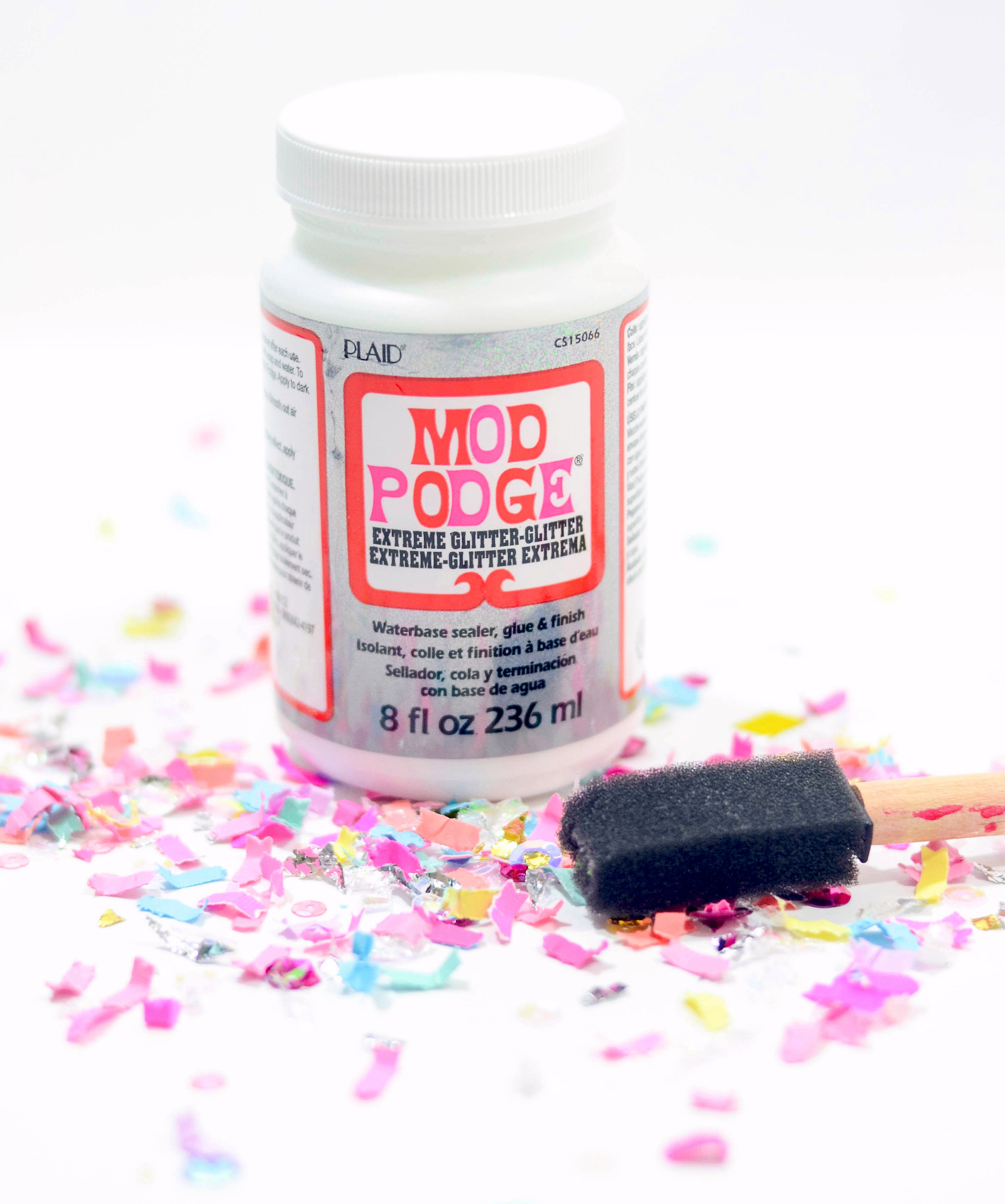 Bottle of Extreme Glitter Mod Podge, confetti, and a foam brush