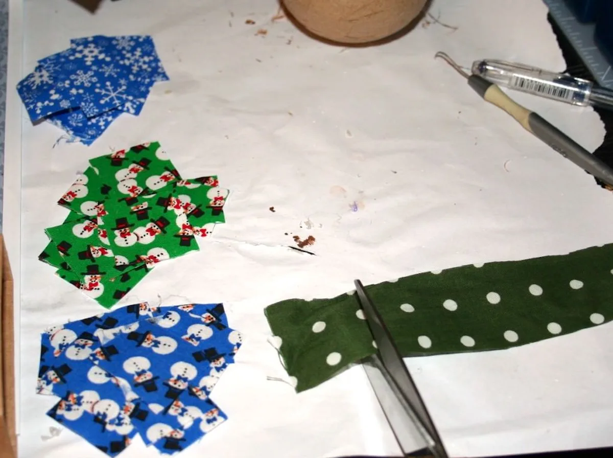 Small piles of Christmas fabric cut into squares