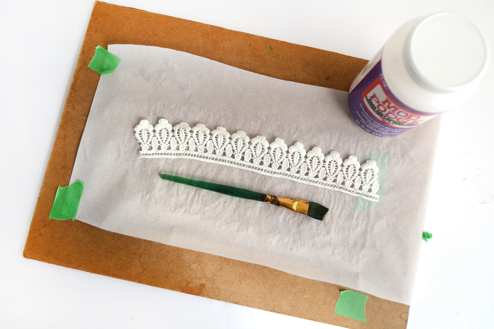 Applying Mod Podge Hard Coat to lace with a paintbrush