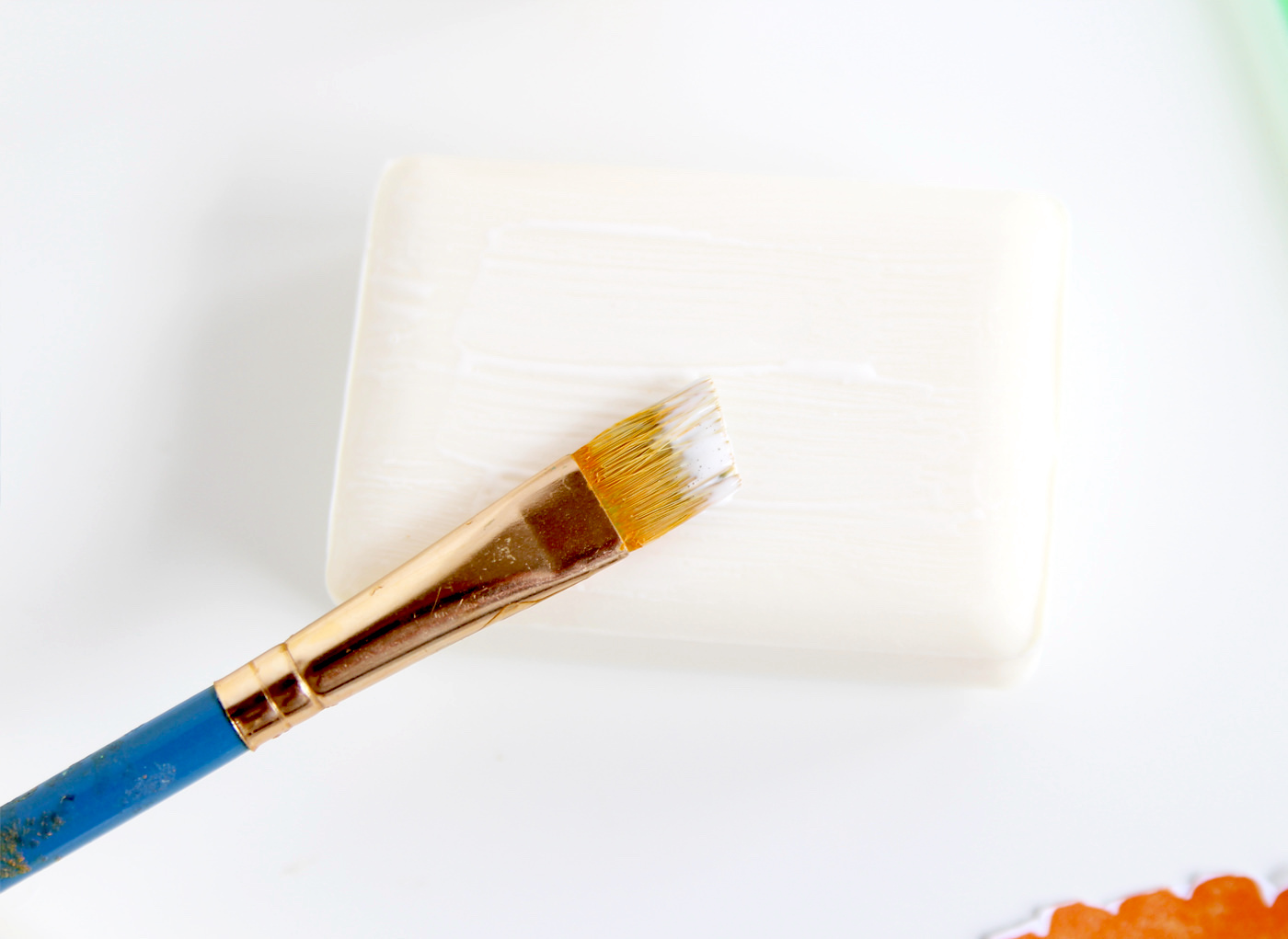 Brushing Mod Podge onto a bar of soap