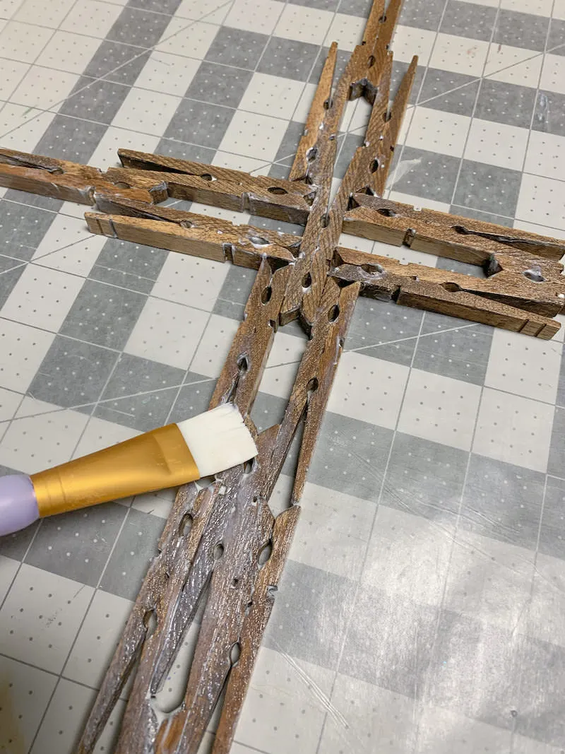 Sealing-a-DIY-clothespin-cross-with-Mod-Podge