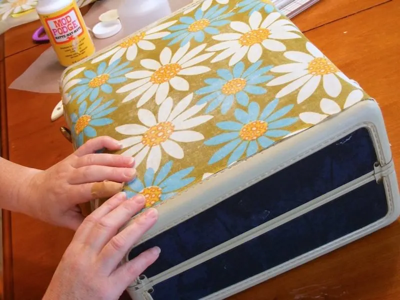 Smoothing fabric on the top of a suitcase