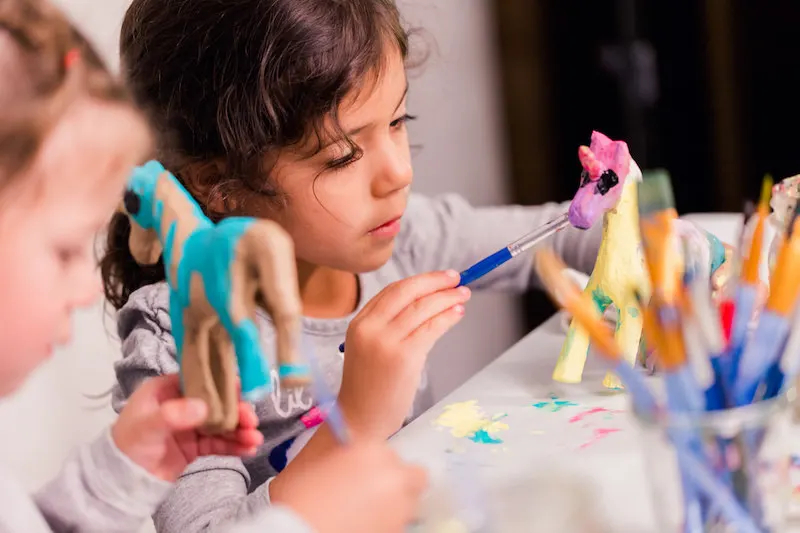 children painting paper mache figures