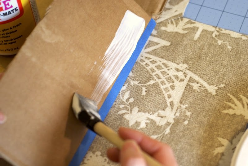 Painting Mod Podge on the flap of a box with a foam brush