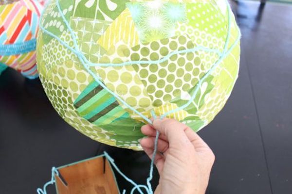 Tying the basket to the balloon with yarn