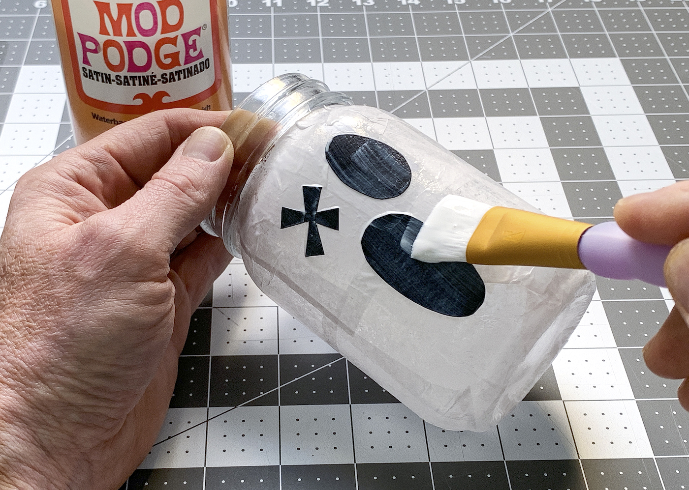 Adding Mod Podge to the top of a ghost mason jar