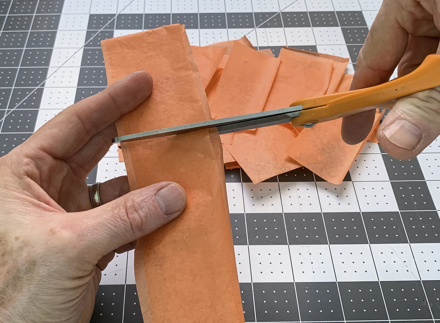 Cutting tissue paper into squares with a pair of scissors