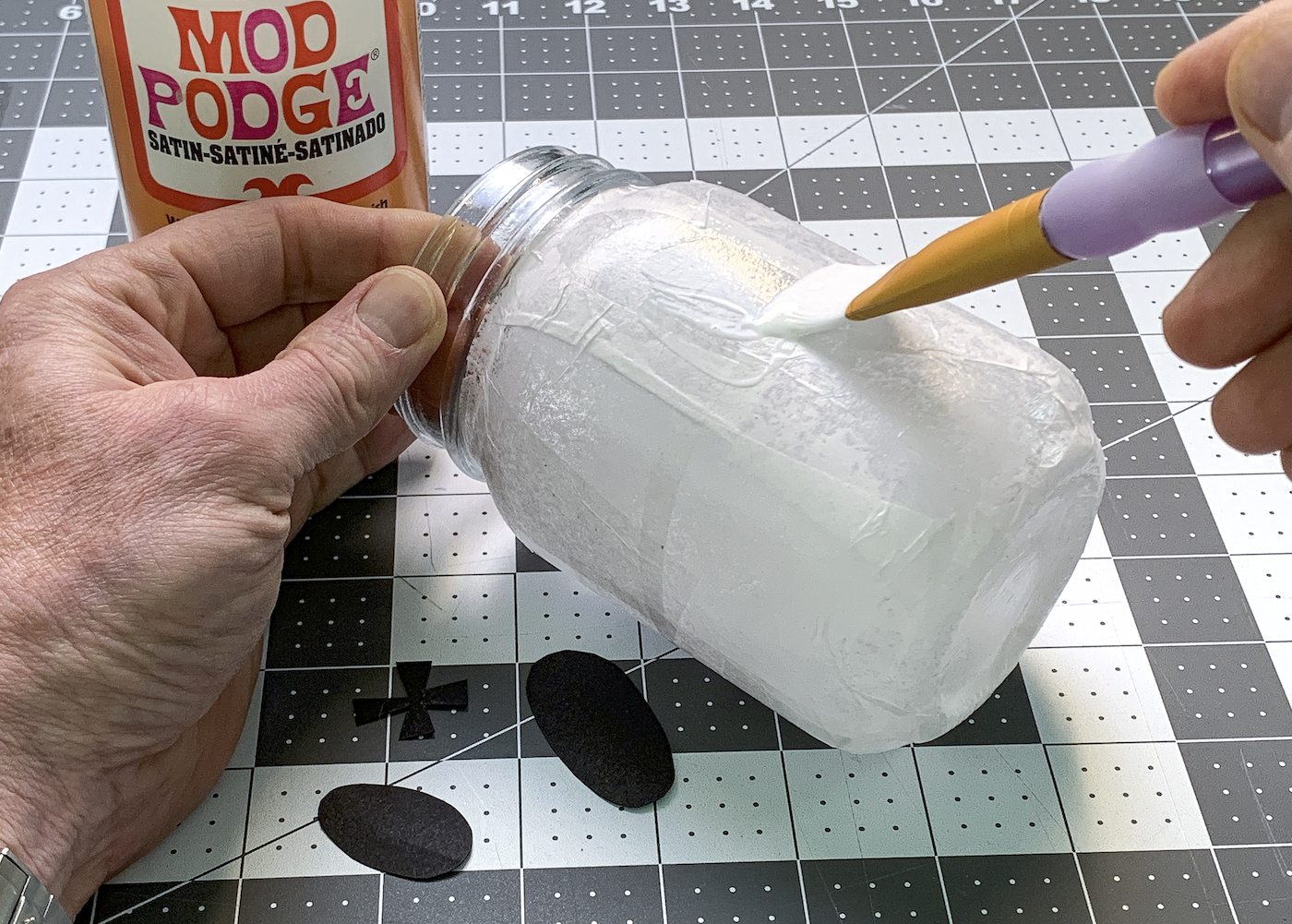 Mod Podging a jar covered in white tissue paper