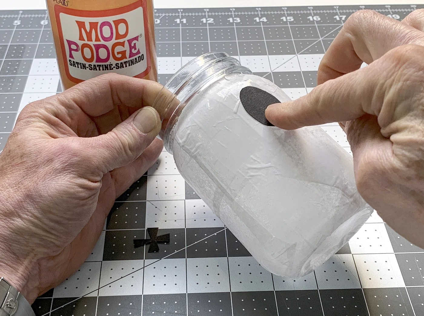 Placing a ghost eye on a Halloween mason jar