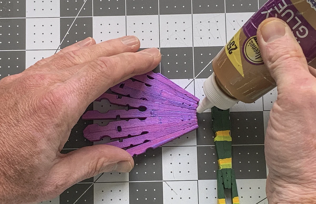 Adding craft glue to a purple dragonfly wing