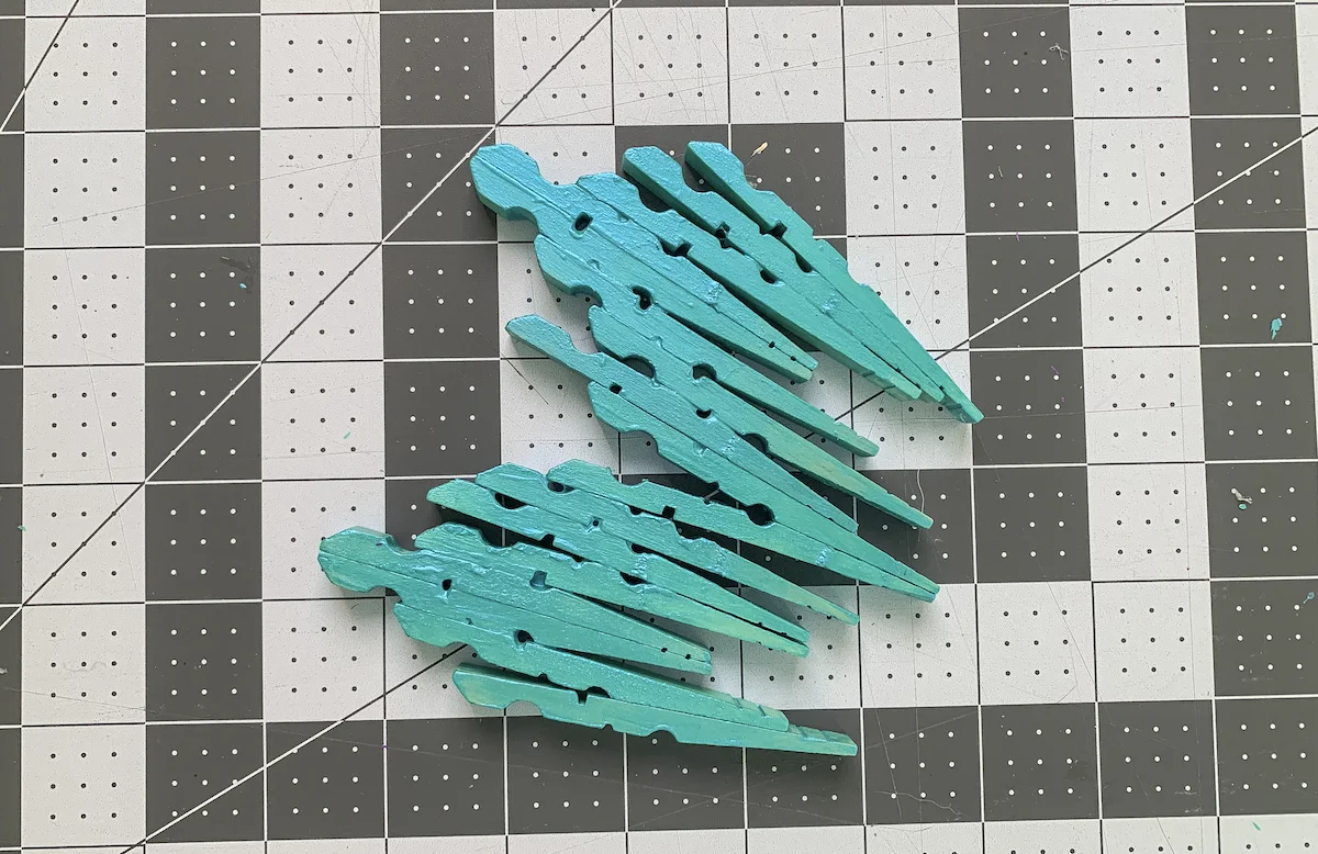 Blue painted clothespins shaped like a dragonfly wing