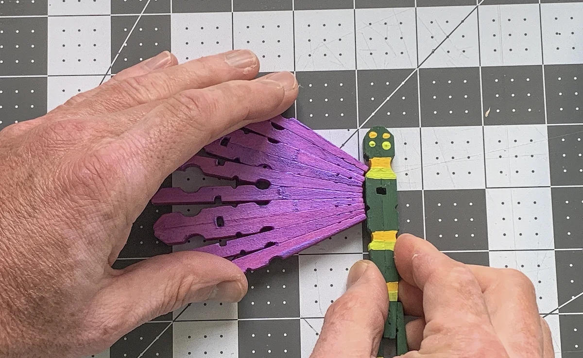 Gluing a clothespin wing onto the dragonfly body