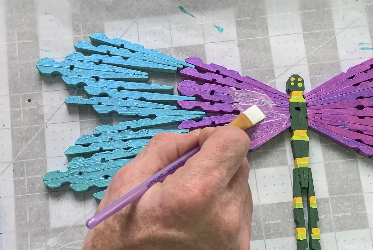 Painting a clothespin dragonfly with Mod Podge