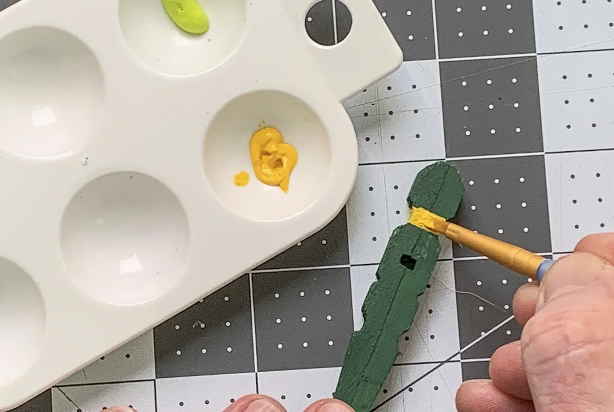 Painting clothespins with yellow craft paint