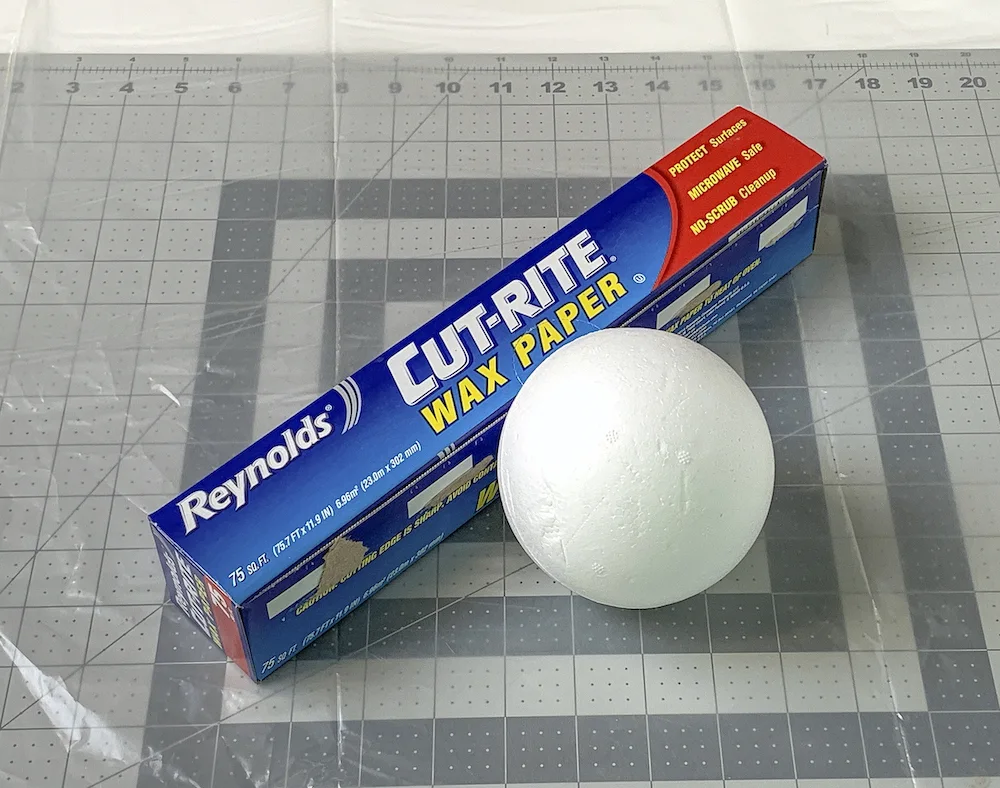 Wax paper in a box and a styrofoam ball