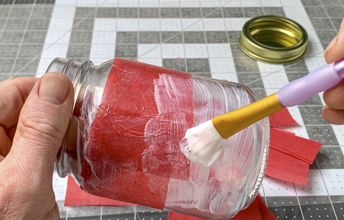 Mod Podging over tissue paper with a paintbrush