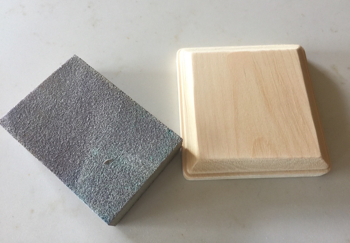 Smoothing out a wood plaque with a sanding block