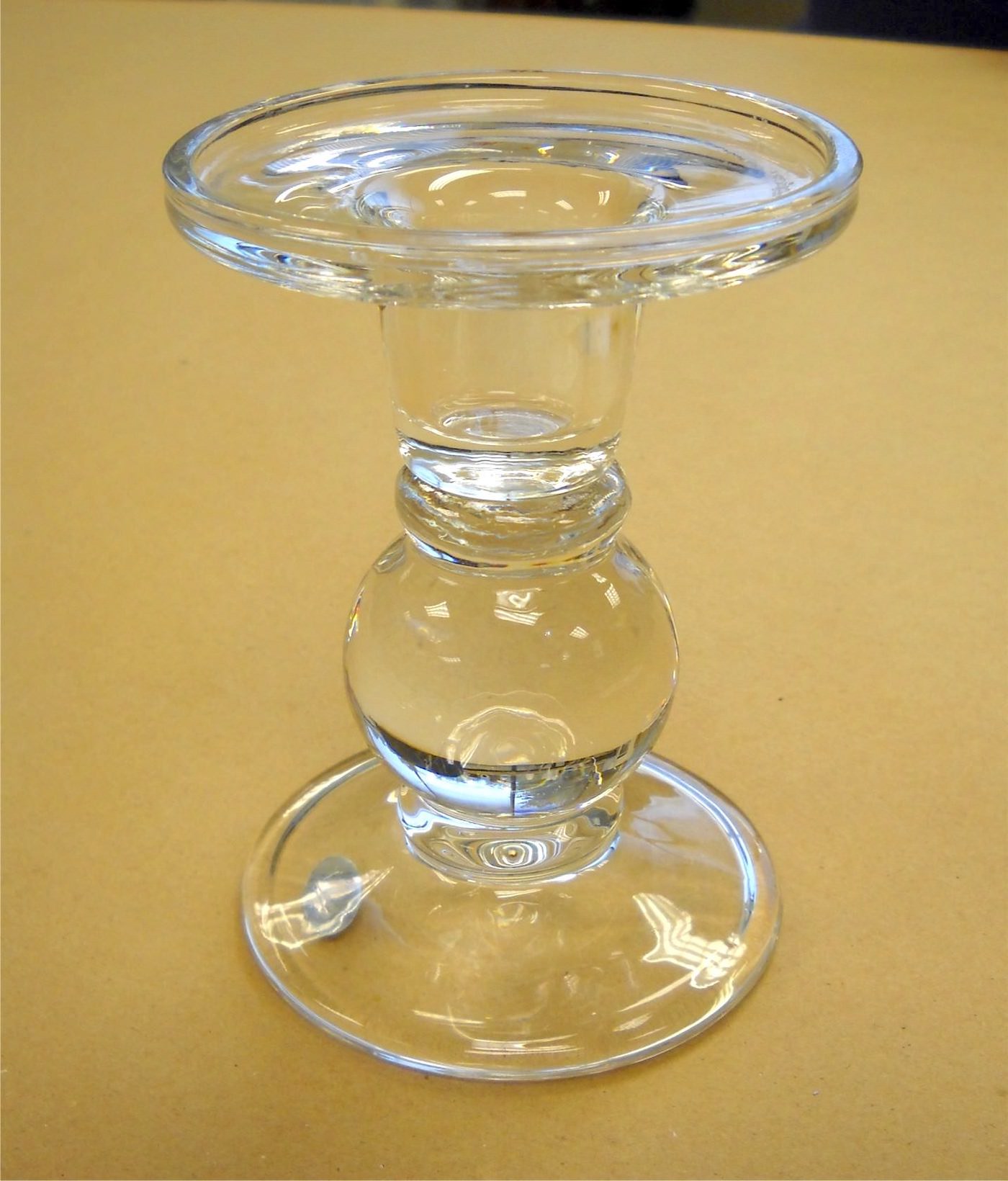 Clean glass candlestick sitting on a work surface