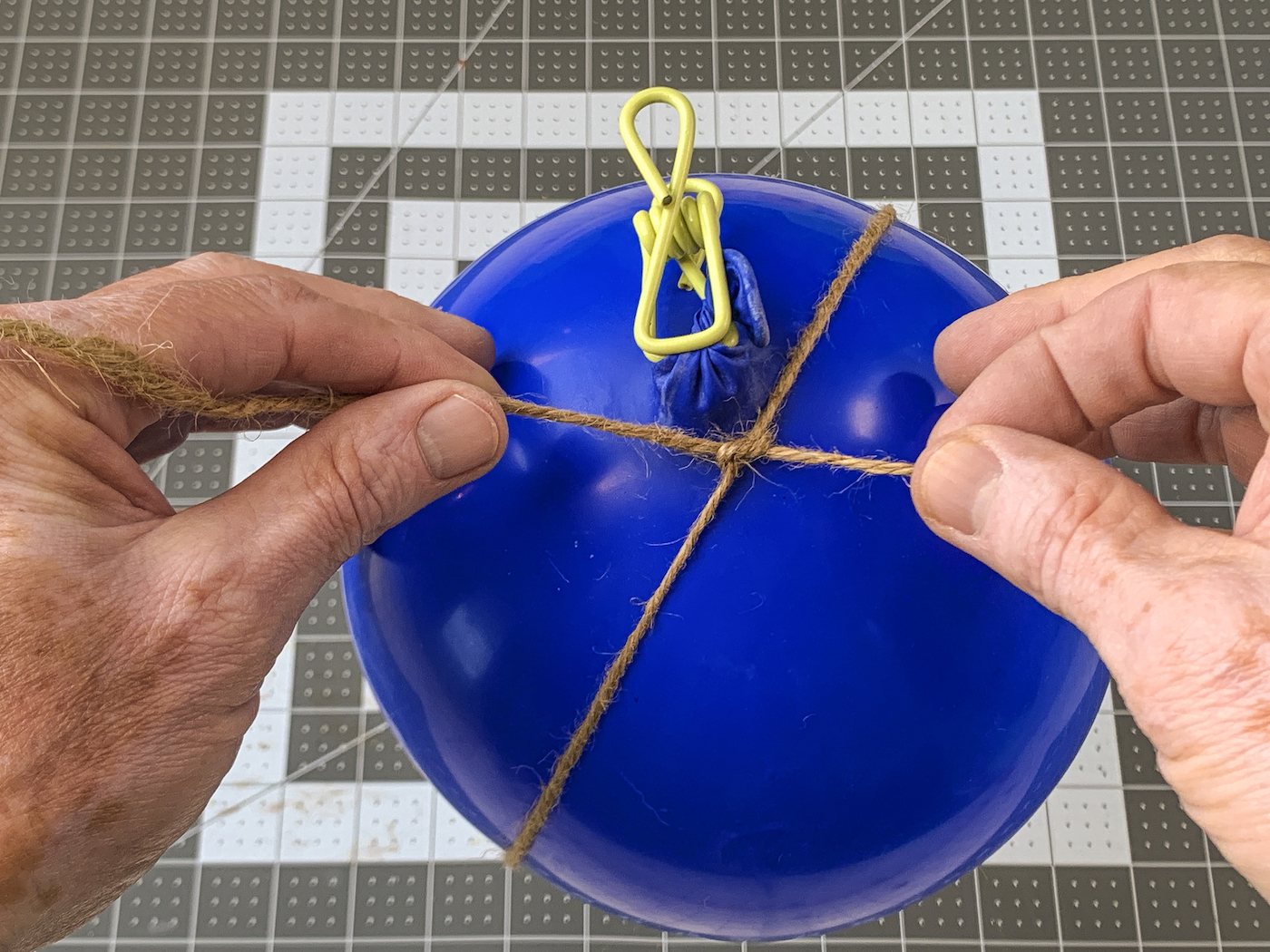 Tying a loop of twine around the balloon